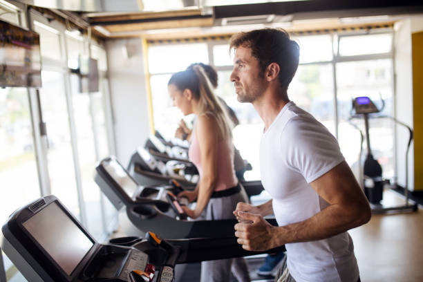 istock Beautiful fit people exercising together in gym 1151962018