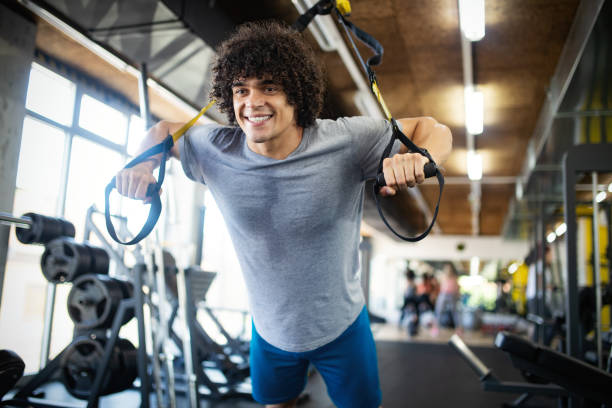 istock Young fit handsome man doing exercises in gym 1151962087