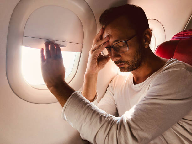 istock Tired / sick passenger in a modern airplane seat next to the window. 1151967511
