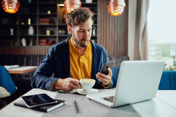 hombre de negocios con teléfono inteligente y beber café en la cafetería. - restaurant wireless technology office worker business fotografías e imágenes de stock