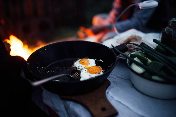 istock fried eggs in a pan by the fire campfire on nature. evening picnic 1151968943