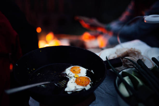 istock fried eggs in a pan by the fire campfire on nature. evening picnic 1151968955