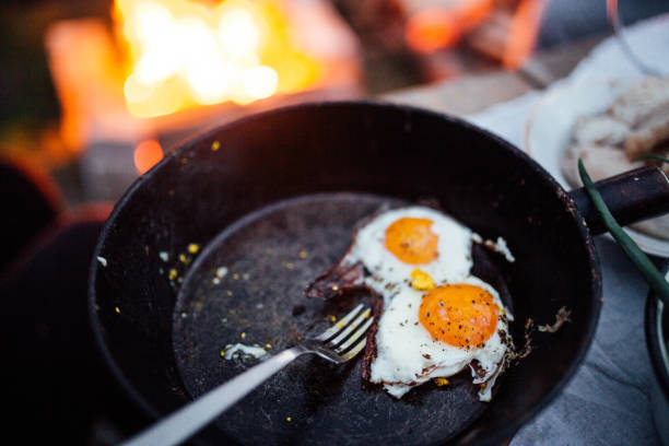 istock fried eggs in a pan by the fire campfire on nature. evening picnic 1151968963
