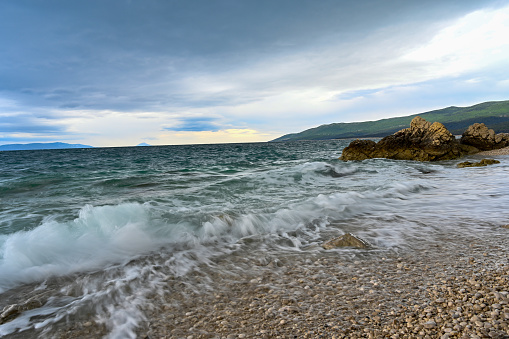 waves coming and going on a pebbely beach in Rabac Croatia may 2019