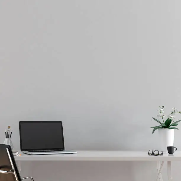 Workdesk with decoration  in front of empty light gray wall with copy space. 3D rendered image.