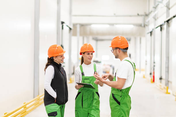 istock Three modern factory coworkers talking. 1151972549
