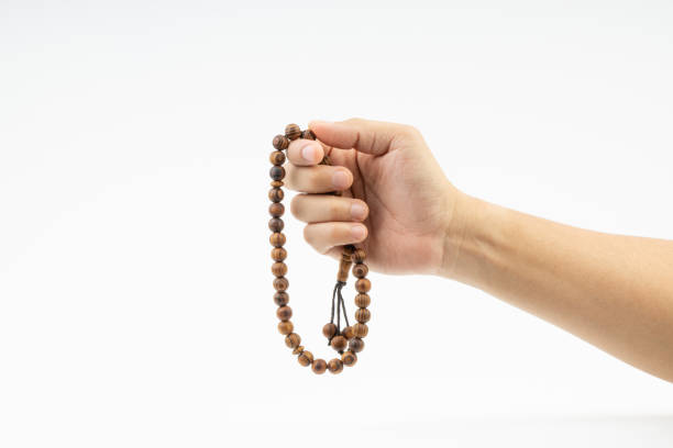istock Hand holding a muslim rosary beads or Tasbih on white background. 1151972946