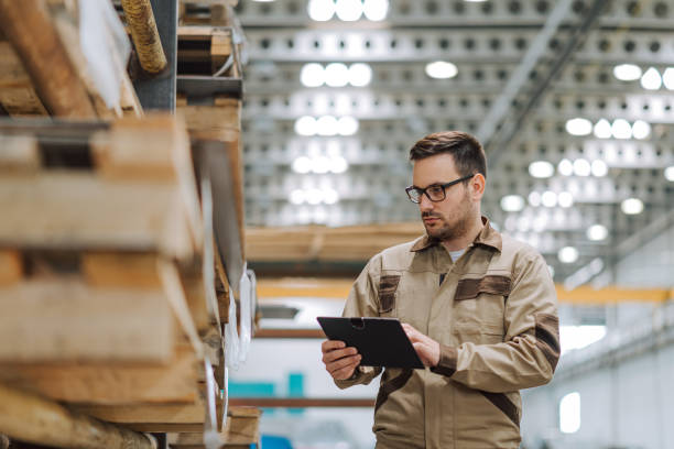 istock Warehouse worker with clipboard working in a large warehouse. 1151973216