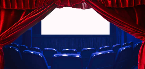 istock Empty cinema auditorium with empty white screen and red theater curtain on the foreground. Empty rows of theater or movie seats. Blue toned. 1151974270