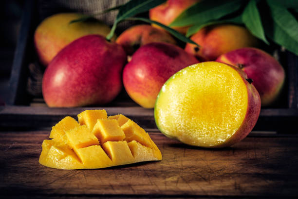 niedriges schlüsselbild nahaufnahme von geschnittenen reifen mangos in der rustikalen küche - breakfast close up vegetarian food nature stock-fotos und bilder
