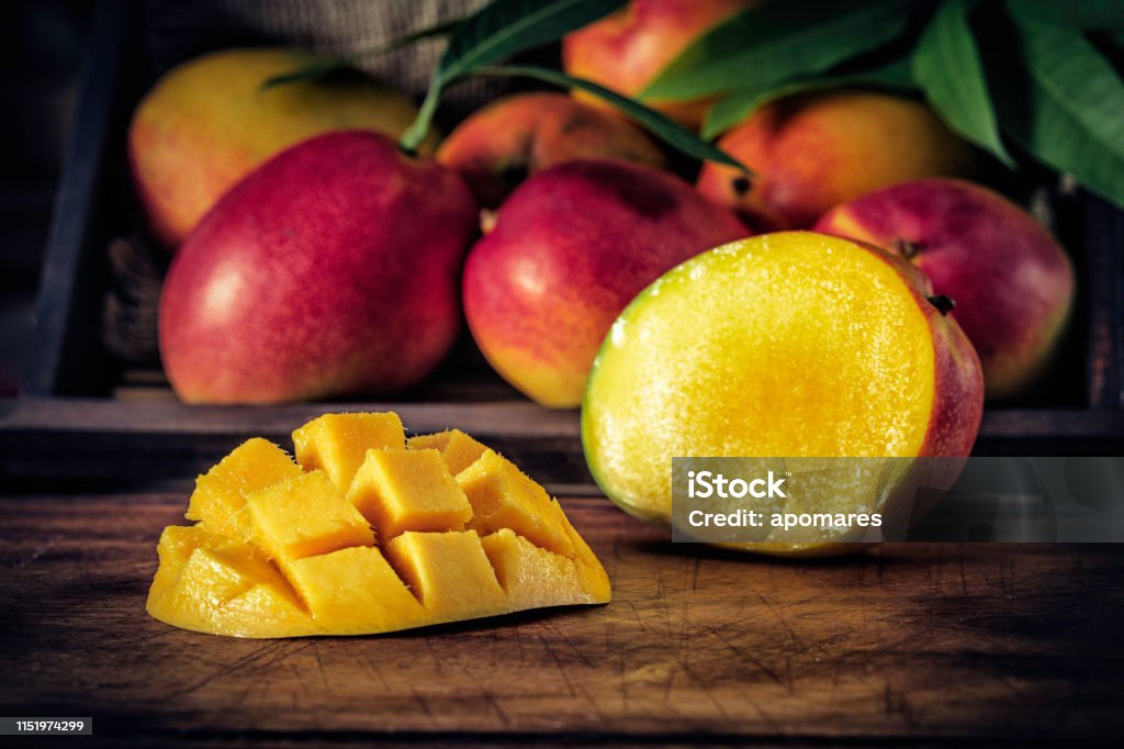 Lage zeer belangrijke beeld close-up van gesneden rijpe mango's in rustieke keuken - Royalty-free Mango Stockfoto
