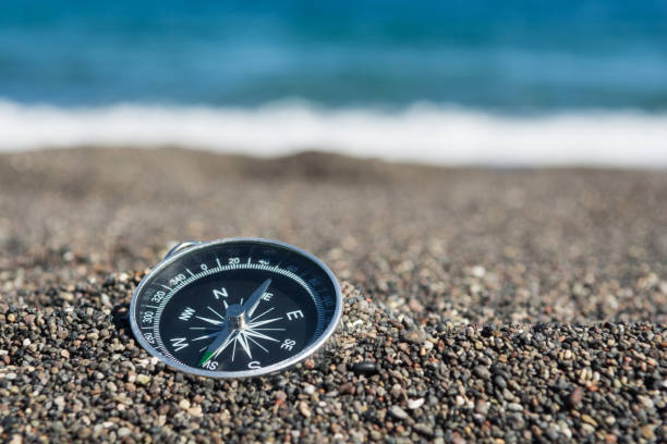 brújula de navegación en la playa, de cerca, enfoque selectivo - compass exploration the way forward beach fotografías e imágenes de stock