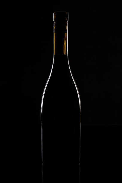 istock Isolated wine bottle on a black background 1151978135
