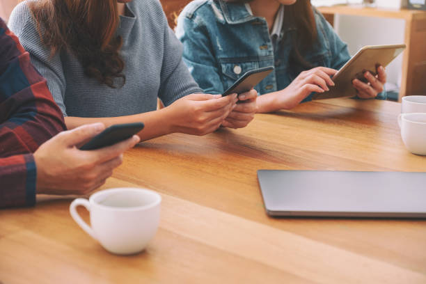 istock Group of people using and looking at mobile phone and tablet pc while sitting together 1151980382