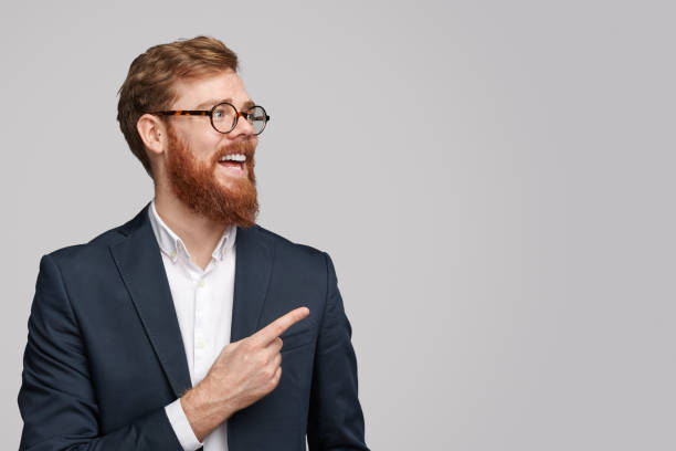 istock Cheerful red haired businessman pointing at copy space 1151982130