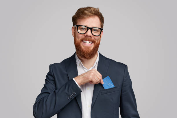 Smiling bearded man showing credit card in pocket
