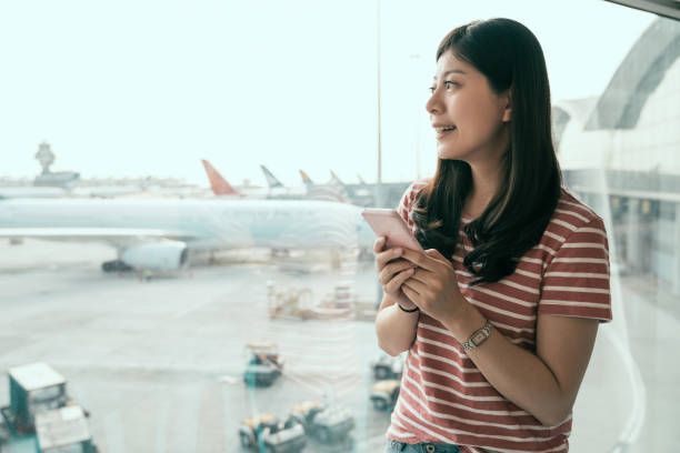 istock girl smiling looking out window airplanes 1151982306
