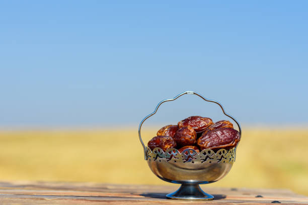 Ramadan Kareem. Dates on field and sky background. Festive still life with copy space.