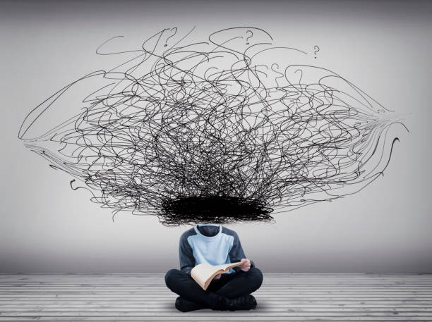 istock Headless man reading a book next to a wall painted with chaotic lines. 1151987450