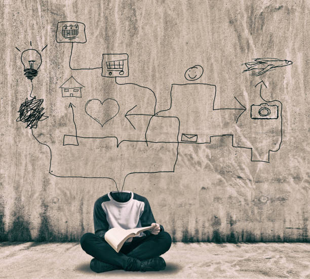 istock Headless man reading a book next to a painted wall. 1151987462