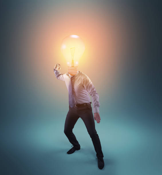 istock Businessman with a lit light bulb instead of head in a challenging posture. 1151987480