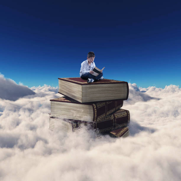 istock Young man reading a book on a tower of books above clouds. 1151987649