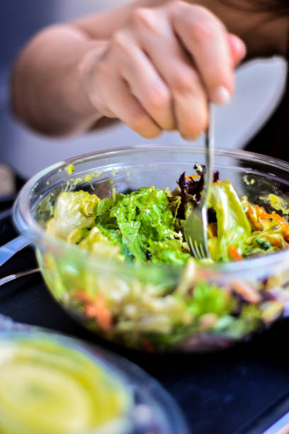 istock Young Woman Eating Salad 1151987672