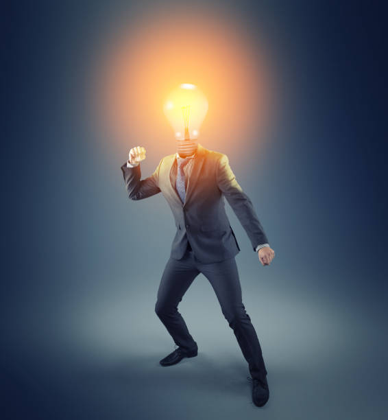 istock Businessman with a lit light bulb instead of head in a challenging posture. 1151987736
