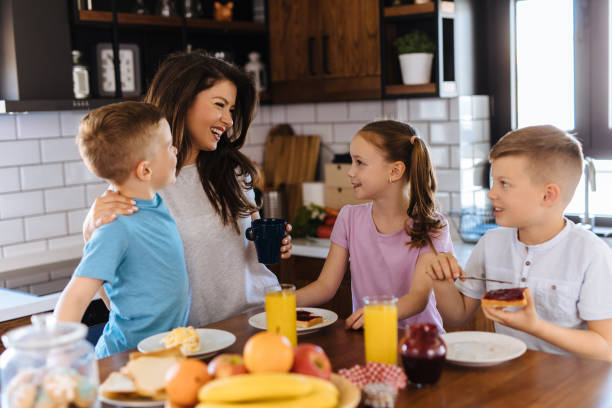 istock Mother and three kids in the kitchen eating breakfast 1151989859