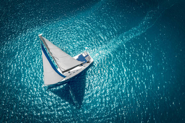 barcos de vela regata con velas blancas en mar abierto. vista aérea del velero en condiciones ventosas - sailboat fotografías e imágenes de stock