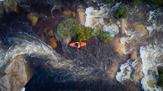 Aerial image of a white water kayaker on a mountain river in flood after good winter rains in south africa
