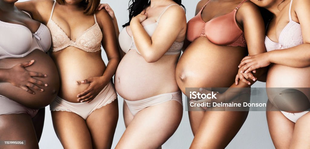 We can't wait to meet our little ones Cropped shot of unrecognisable pregnant women posing together with their hands on their bellies in the studio Pregnant Stock Photo