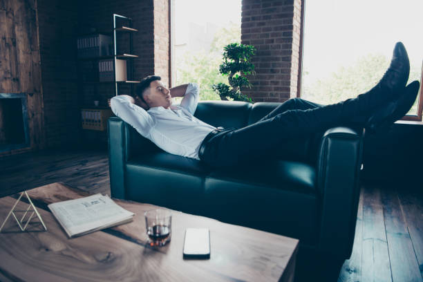 istock Full length side profile body size photo handsome he him his hands arms behind head napping after pause break reading press wear formal-wear dress code shirt lying couch divan indoors modern office 1151995372