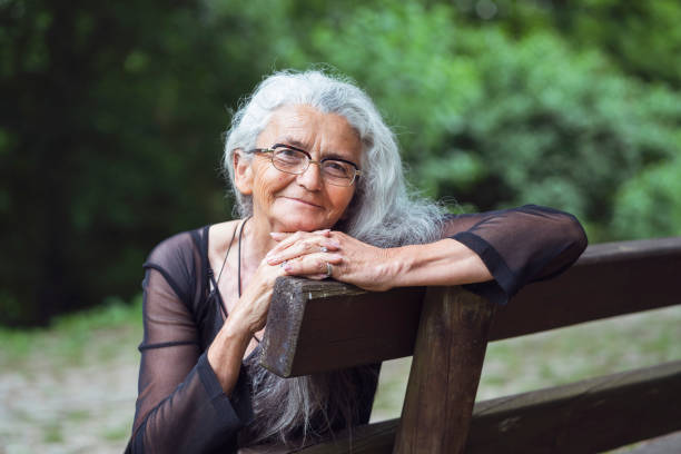 istock Senior woman sitting in park 1151997555