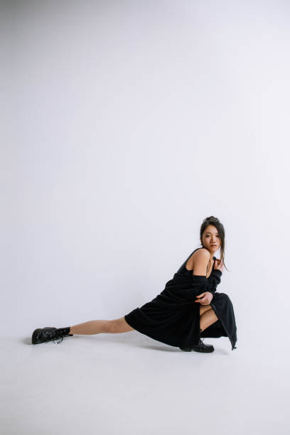 istock Young female ballet dancer against white studio background 1151997874
