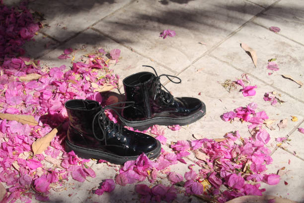 istock Black boots among pink petals 1151999337