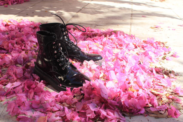 istock Black boots among pink petals 1151999530