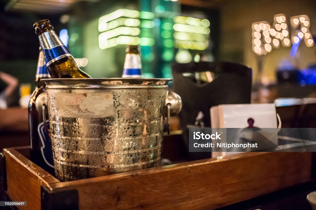 ice bucket of cold bottles beer In the bar and restaurant setting . Beer - Alcohol Stock Photo