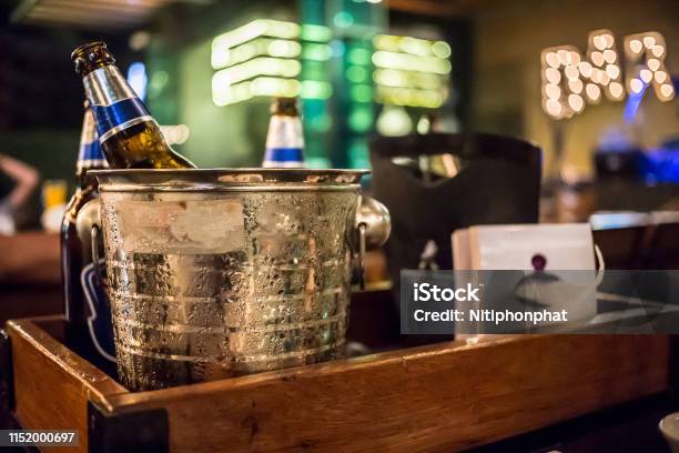 Ice Bucket Of Cold Bottles Beer In The Bar And Restaurant Setting Stock Photo - Download Image Now