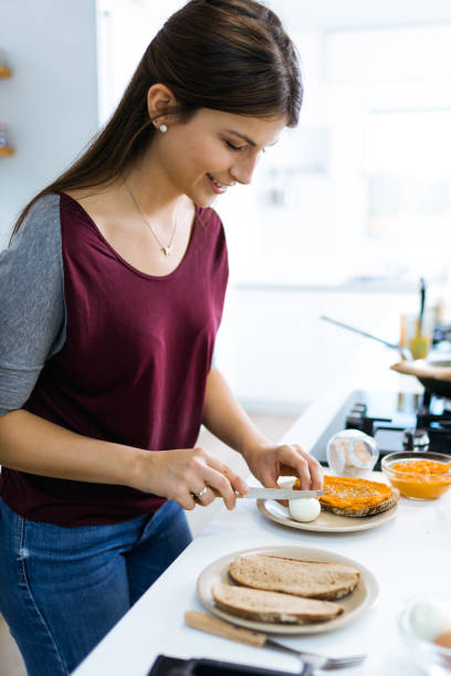 istock Beautiful woman preparing toast with mashed vegetables and hard-boiled egg. 1152000703