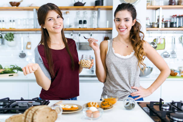 istock Two beautiful women preparing toasts with mashed vegetables, eggs and seeds. 1152001561