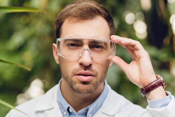istock thoughtful scientist in white coat and goggles in green orangery 1152001688