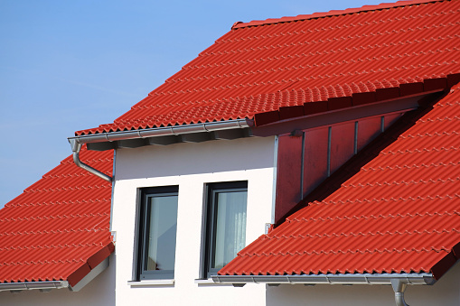 Dormer with stainless steel cladding on a new roof with red tiles