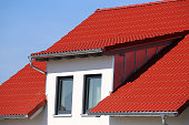 Dormer with stainless steel cladding on a new roof with red tiles