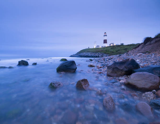istock Lighthouse beacon sitting on a cliff overlooking the ocean during sunset. 1152005167
