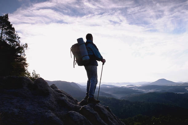 Climber with hiking backpack go to the mountains. Hikers in mountains. Male strong carrier with backpack and camping on hike in nature. Travel Concept