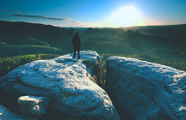istock Man silhouette stay on sharp peak. Satisfy hiker enjoy view. 1152007573