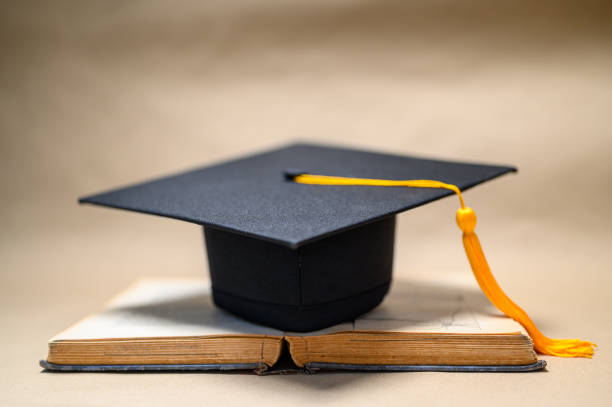 istock Black Graduation Hat placed on old books 1152011764
