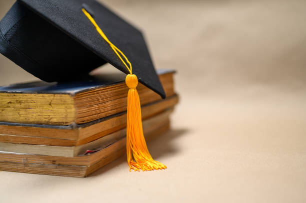 istock Black Graduation Hat placed on old books 1152012275