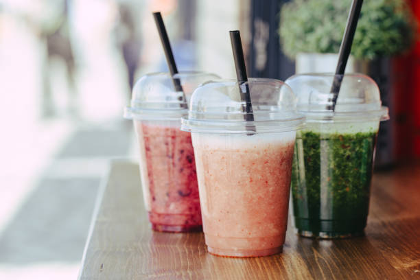 istock Sweet smoothie in plastic cups on wooden table 1152013668